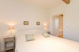 1 dormitorio con 1 cama blanca y 2 almohadas en Küsterhäuschen - Schloss Gelting, en Gelting