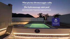 a swimming pool in a building with a sign at Ischia Mavilan Luxury Apartments in Ischia