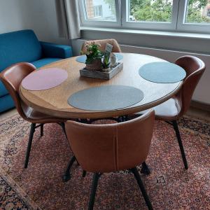een tafel en stoelen in de woonkamer bij De Distel in Oostende