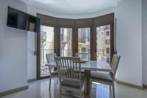 een eetkamer met een tafel en stoelen en een balkon bij Apartamento Arbones de Manresa in Manresa