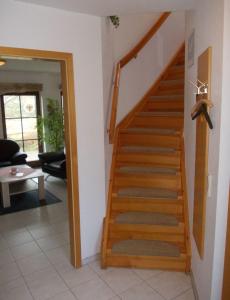- un escalier en bois dans une chambre avec un salon dans l'établissement Finnhäuser am Vogelpark - Haus Annika, à Marlow
