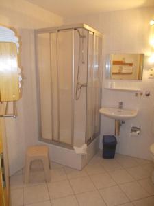 La salle de bains est pourvue d'une douche et d'un lavabo. dans l'établissement Finnhäuser am Vogelpark - Haus Annika, à Marlow