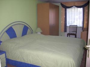 ein Schlafzimmer mit einem großen Bett und einem Stuhl in der Unterkunft Ferienwohnung Stoll in Brüel
