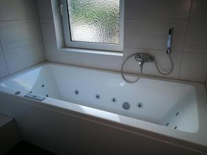 a white bath tub in a bathroom with a window at Ferienwohnung Stoll in Brüel