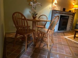 a dining room table with four chairs and a fireplace at Le Charme in Mézilles +10 photos