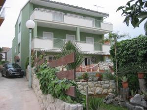 a house with a retaining wall in front of it at Apartmani- Šjor -Primošten-Apartmani- has 2 large apartments and 2 smaller ones -Primošten Lokvice 6 in Primošten
