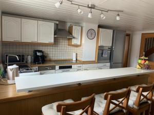cocina con armarios blancos y encimera blanca en Allgäu Apartment, en Memmingen