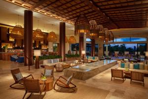 a lobby of a resort with chairs and a bar at Secrets Maroma Beach Riviera Cancun - Adults only in Playa del Carmen