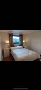 a bedroom with a large bed and a window at The Countryman Inn in Llantrisant