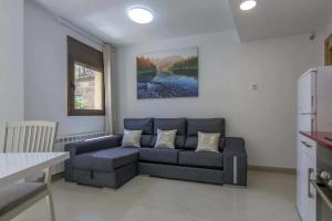 a living room with a couch and a kitchen at Kisa Apartments de Manresa in Manresa
