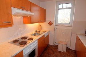 a kitchen with a stove and a sink and a window at Residenz "Am Postplatz", Whg 15 in Zingst