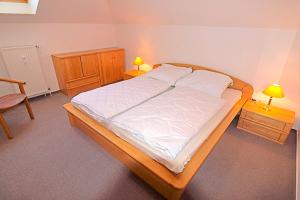 Bett in einem Zimmer mit 2 Tischen und 2 Lampen in der Unterkunft Residenz "Am Postplatz", Whg 15 in Zingst
