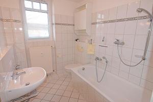 ein weißes Badezimmer mit einer Badewanne und einem Waschbecken in der Unterkunft Residenz "Am Postplatz", Whg 15 in Zingst