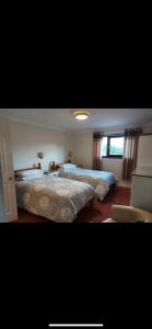 a bedroom with two beds and a window at The Countryman Inn in Llantrisant