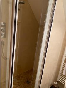 a shower with a glass door in a bathroom at Le Charme in Mézilles