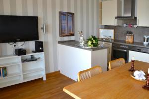 eine Küche mit einem Esstisch und einem TV in der Unterkunft Traumblick FeWo Nr 79 in Sierksdorf