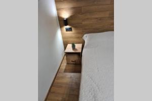 a bedroom with a white bed and a wooden wall at Хотелски апартамент Стило в идеалния център. in Veliko Tŭrnovo