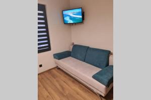 a living room with a couch and a keyboard on the wall at Хотелски апартамент Стило в идеалния център. in Veliko Tŭrnovo