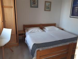 a small bedroom with a bed with white sheets at Apartmani Sanja in Šibenik