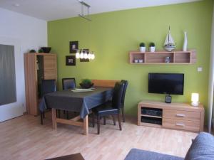 een woonkamer met een eettafel en een televisie bij 2 min zum Strand in Borkum
