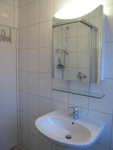 een witte badkamer met een wastafel en een spiegel bij 2 min zum Strand in Borkum