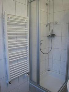 een douche met een glazen deur in de badkamer bij 2 min zum Strand in Borkum