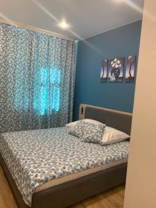 トリヤッチにあるTri Zvezdy Hotelの青い壁のベッドルーム1室(ベッド1台付)