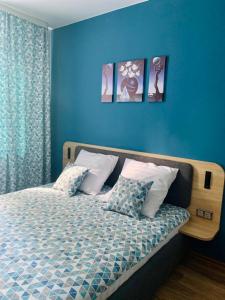 トリヤッチにあるTri Zvezdy Hotelのベッドルーム1室(青い壁、枕付きのベッド1台付)