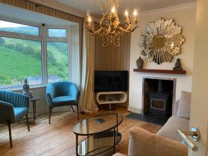 a living room with a chandelier and a fireplace at Beautiful 5 Bedroom, Amazing Water & Valley Views in Dartmouth