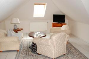 a living room with two chairs and a tv at Privatzimmer Ehrhardt Nr2 in Burg auf Fehmarn