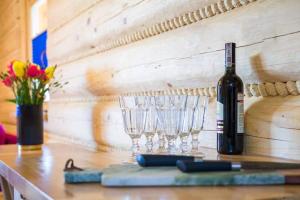 una botella de vino y dos copas de vino en una mesa en Beskid Wood Houses en Istebna