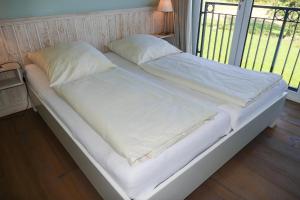 a large bed with white sheets and pillows on it at Fehmarn-OstseeferienStrandresidenz Vogelflug 14519 App 19 in Fehmarnsund