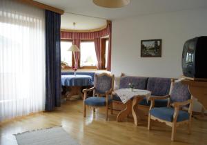 a living room with a table and chairs and a television at Ferienwohnungen Billovits in Kössen