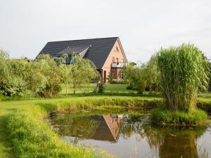 a house and a pond in front of a house at Fewo 1 "Landhaus am Grashof" in Offenbüttel