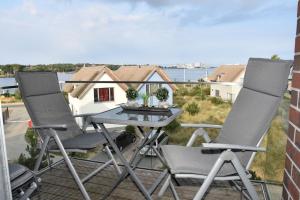 a patio with two chairs and a table on a balcony at Ostsee - Appartement Nr 22 "Ankerplatz" im Strand Resort in Heiligenhafen