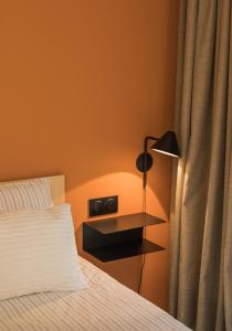 a bedroom with a bed and a nightstand with a lamp at Salty Woods Lodge, Chambre d'hôtes in Vieux-Boucau-les-Bains