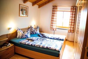 Schlafzimmer mit einem Bett mit blauer Bettwäsche und einem Fenster in der Unterkunft Ferienwohnung "Panoramablick" in Achslach