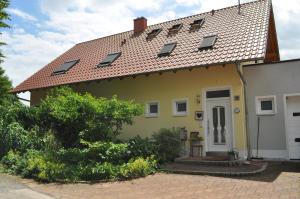 a yellow house with solar panels on the roof at Ferienwohnung Kästle in Bad Bergzabern