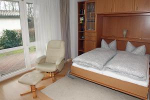 a bedroom with a bed and a chair and a window at Likedeeler Weg 1 Whg 18 in Zingst
