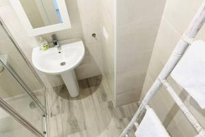 biała łazienka z umywalką i prysznicem w obiekcie Precioso apartamento con vistas parciales, garaje y piscina w mieście Tarifa