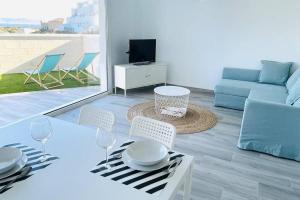 salon ze stołem, krzesłami i kanapą w obiekcie Precioso apartamento con vistas parciales, garaje y piscina w mieście Tarifa
