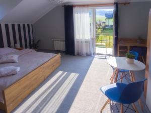 a bedroom with a bed and a table and chairs at Leśne Zacisze in Weremień