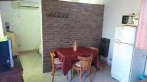 a kitchen with a table with a candle on a brick wall at Abuelo Coqui in Ramallo