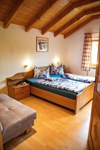 ein Schlafzimmer mit einem großen Bett in einem Zimmer mit Holzdecken in der Unterkunft Ferienwohnung "Panoramablick" in Achslach