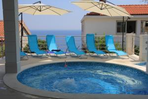 una piscina con sedie e ombrelloni su un balcone di Apartmani Marelic - Sun Beach a Zavalatica