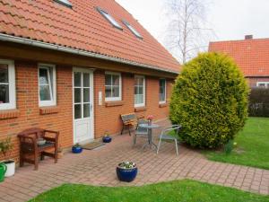 a brick house with a patio with a table and chairs at Ferienhof Böhnke Nr3 in Puttgarden