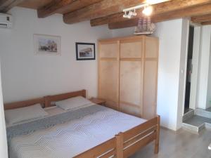 - une chambre avec un lit et une armoire en bois dans l'établissement Apartmani Sanja, à Šibenik
