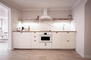 a kitchen with white cabinets and a stove at Boutique Charme Apartments Langestr 14 in Baden-Baden