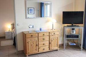 a room with a television and a wooden dresser at Ostseeresidenz - Whg 24 in Zingst
