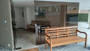 Zimmer mit 2 Holzbänken und einem Tisch in der Unterkunft Lindo Apartamento Enseada in Guarujá